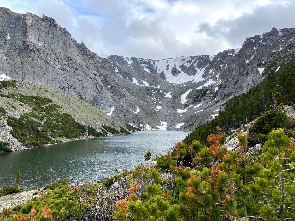 Sylvan Lake in a high alpine bowl, ringed by cliffs, snowfields, and pine.